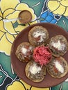 Garnachas appetizer served on clay plate. Crispy corn tortilla served with shredded beef, salsa, cheese, and pickled cabbage.