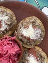 Garnachas appetizer served on clay plate. Crispy corn tortilla served with shredded beef, salsa, cheese, and pickled cabbage.