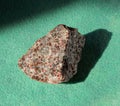 Garnet almandine crystal blotches inside rock. A mineral on green background. Found near Miass city, Ural, Russia Royalty Free Stock Photo