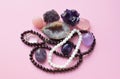 Garnet beads and amethyst, rose quartz and rock crystal crystals on a pink background Royalty Free Stock Photo