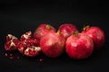 Garnet fruits and pulp on black background. Fresh pomegranate fruits and seeds close up.