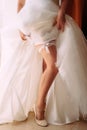 Garter Bride. Beautiful slim leg of young woman wearing white wedding dress