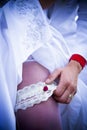 Garter bride leg and bridegroom hand with gold ring Royalty Free Stock Photo