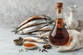 Garum fish sauce in a decanter on the table with fresh sardines and spices.