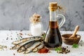 Garum fish sauce in a decanter on the table with fresh sardines and spices.