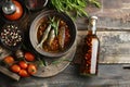 Garum fish sauce in a deep bowl with spices and tomatoes on a wooden table.