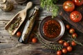 Garum fish sauce in a deep bowl with spices and tomatoes on a wooden table.