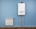 Gas boiler and heater radiator with pipelines on blue wall in house. Heating system