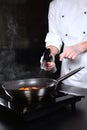 Gas burner in the hands of the chef. Cooking flamb dishes from berries and fruits.Flaming of fruits and berries on fire Royalty Free Stock Photo