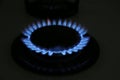 Gas burner of modern stove with burning blue flame at night, closeup Royalty Free Stock Photo