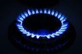 Gas burner of stove with burning blue flame at night, closeup Royalty Free Stock Photo