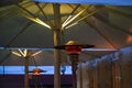 Gas burning patio heater on a restaurant terrace with bad environmental effects, allows dining outside, which reduces the risk of Royalty Free Stock Photo