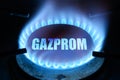 Gas burns in dark at home, blue fire flame and name Gazprom on stove ring burner Royalty Free Stock Photo