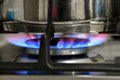 Gas cooking. The blue flames of the gas heat the food in the container Royalty Free Stock Photo