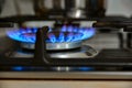 Gas cooking. The blue flames of the gas heat the food in the container Royalty Free Stock Photo