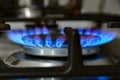 Gas cooking. The blue flames of the gas heat the food in the container Royalty Free Stock Photo