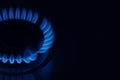 Gas cooktop with burning flame in darkness, closeup. Space for text Royalty Free Stock Photo