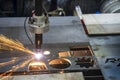 The gas cutting machine cutting the metal plate with the sparkling light.