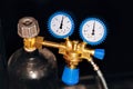 Gas cylinder with reducer, pressure gauge and valve on black background Royalty Free Stock Photo