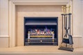 Gas fired classic looking fireplace with tools on the side Royalty Free Stock Photo