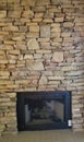 Gas fireplace insert in a natural stone wall Royalty Free Stock Photo