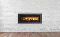 Gas Fireplace on white brick wall in bright empty living room interior of house Royalty Free Stock Photo