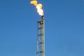 Gas flare is releasing and burning to the atmosphere at an offshore gas platform with sky. Royalty Free Stock Photo