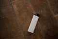 A gas-fueled lighter against a wooden table as a background