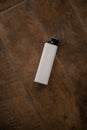 A gas-fueled lighter against a wooden table as a background