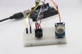 Gas leakage detection system prototype using MQ2 gas sensor, buzzer, breadboard and some microcontroller on the background showing