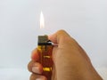 A gas lighter that is burning in right hand. White background Royalty Free Stock Photo