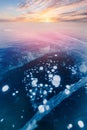 Gas methane bubbles frozen in winter ice of lake Baikal with sunset, abstract background Royalty Free Stock Photo