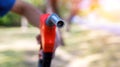 Gas nozzle with one last drop. Orange gasoline nozzle on nature background. Refill and filling Oil Gas Fuel on nature  background. Royalty Free Stock Photo