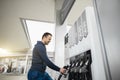 Gas petrol station. Outdoor shot of young handsome Caucasian man in casual outfit, refueling his car with gasoline Royalty Free Stock Photo