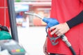 Gas station attendant in red uniform holding a fuel petrol pump nozzle against at gas station Royalty Free Stock Photo