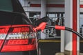 The gas station gun is inserted into the gas tank for refueling. Close-up view Royalty Free Stock Photo