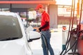 Gas station male man worker staff happy service working refill car gasoline fuel to traveler cars Royalty Free Stock Photo