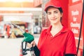 Gas station service staff worker women happy smiling with fuel nozzle for car gasoline refill job Royalty Free Stock Photo