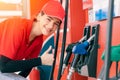 Gas station women worker staff Thumbs up at fuel nozzle dispensers happy service working refill cars gasoline