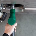 Gas station worker filling up bronze pickup truck tank Top View. Closeup hand holding green gas pump nozzle Royalty Free Stock Photo