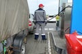 Gas station worker refueling a car with a trailer