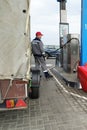 Gas station worker refueling a car with a trailer