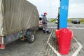 Gas station worker refueling a car with a trailer