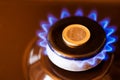 gas stove burner with one euro coin laid on top, burning natural gas with blue flame Royalty Free Stock Photo