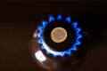 gas stove burner with one euro coin laid on top, burning natural gas with blue flame Royalty Free Stock Photo