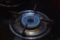 Gas stove burner top view. Propane and butane gas burning in blue flames in the dark