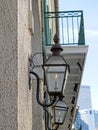 A gas street lamp with a finial atop adorns an old building in New Orleans