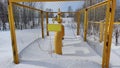 Gas valves with snow in winter frost. Gas line valves behind the metal fence Royalty Free Stock Photo