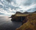 Gasadalur village and Mulafossur its iconic waterfall, Vagar, Faroe Islands, Denmark. Rough see in the north atlantic