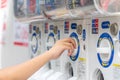 Gashapon or capsule machine women inserts coin to Japanese capsule toy vending machine Gachapon